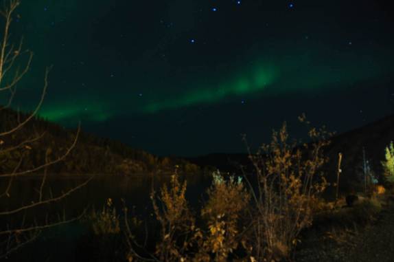 As cores da Aurora reflerem no Yukon River, em Dawson City, no noroeste do Canadá